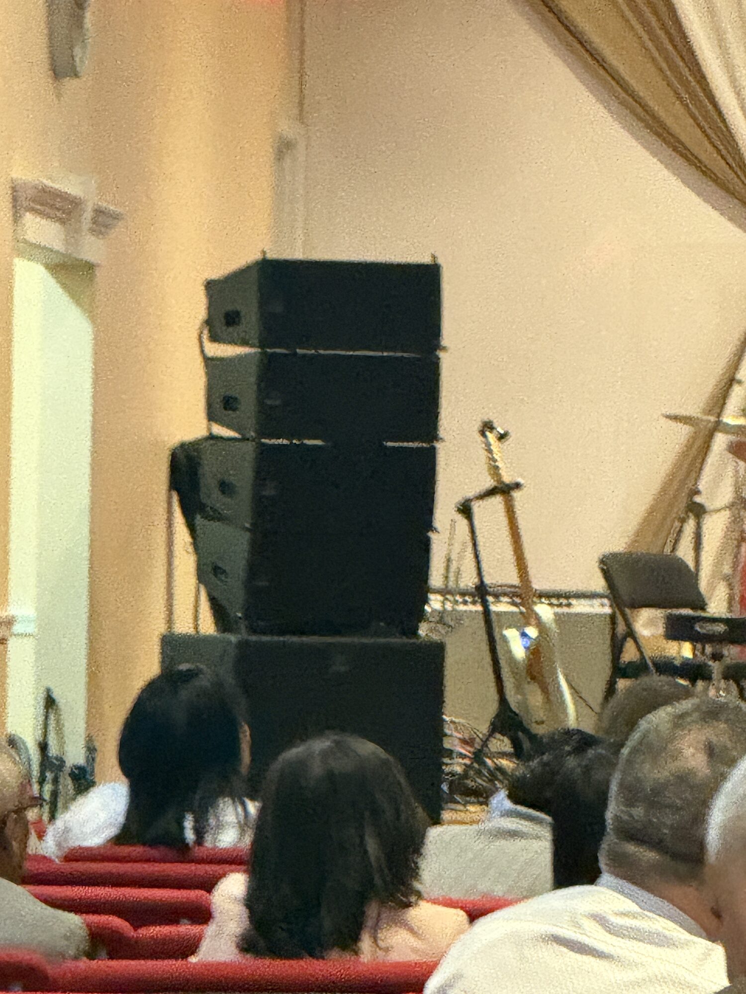 Church convention auditorium with loudspeaker coverage positioned beside seated attendees