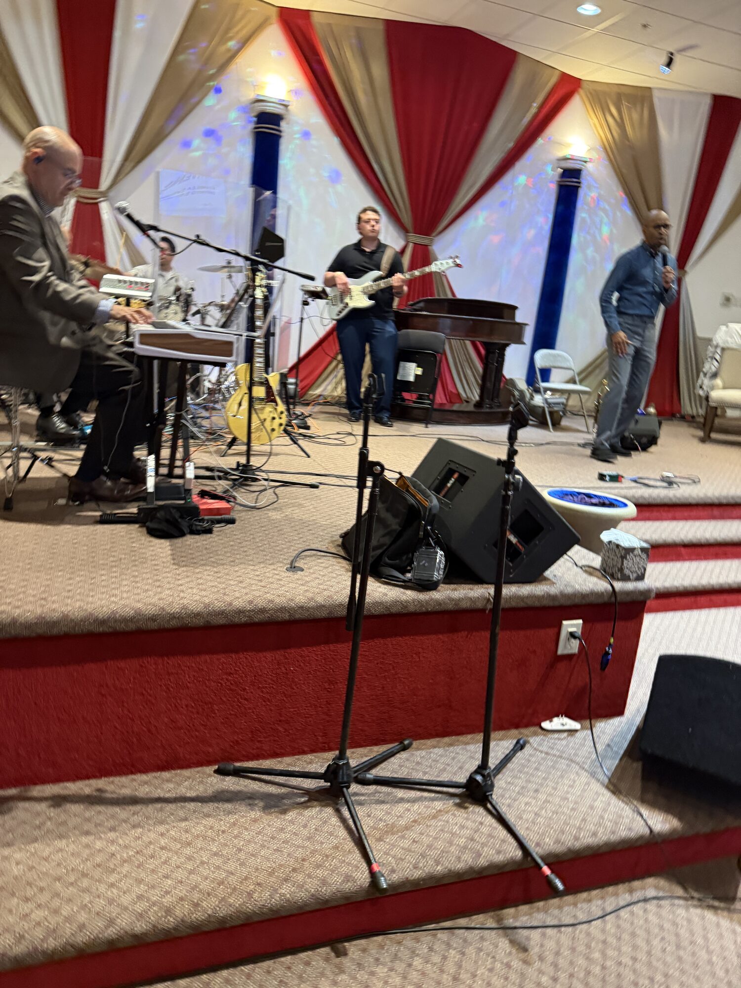 Worship band performing on the convention stage with microphones, instruments, and stage monitors