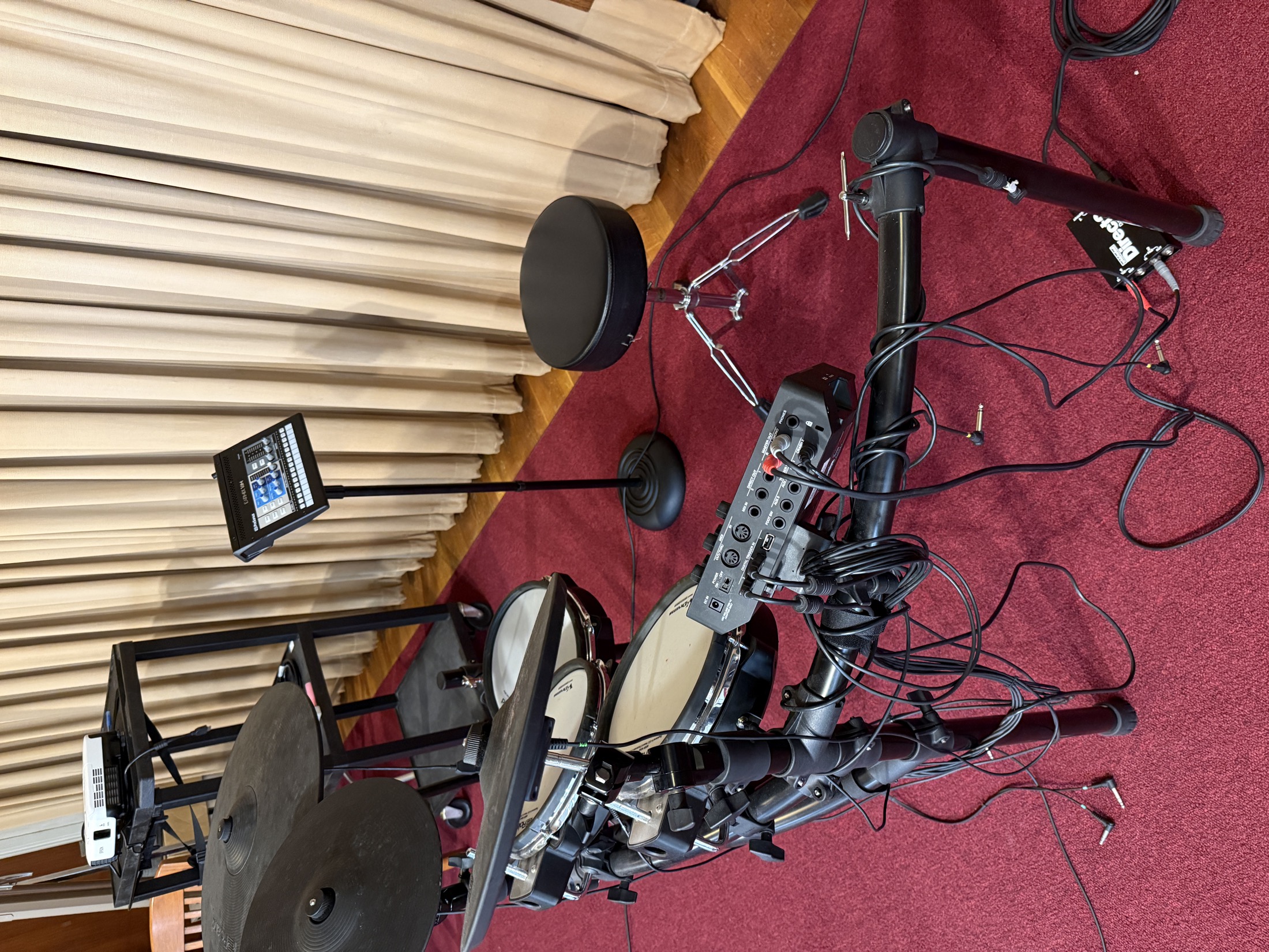 Electronic drum kit with connected audio hardware and monitor display in a church room