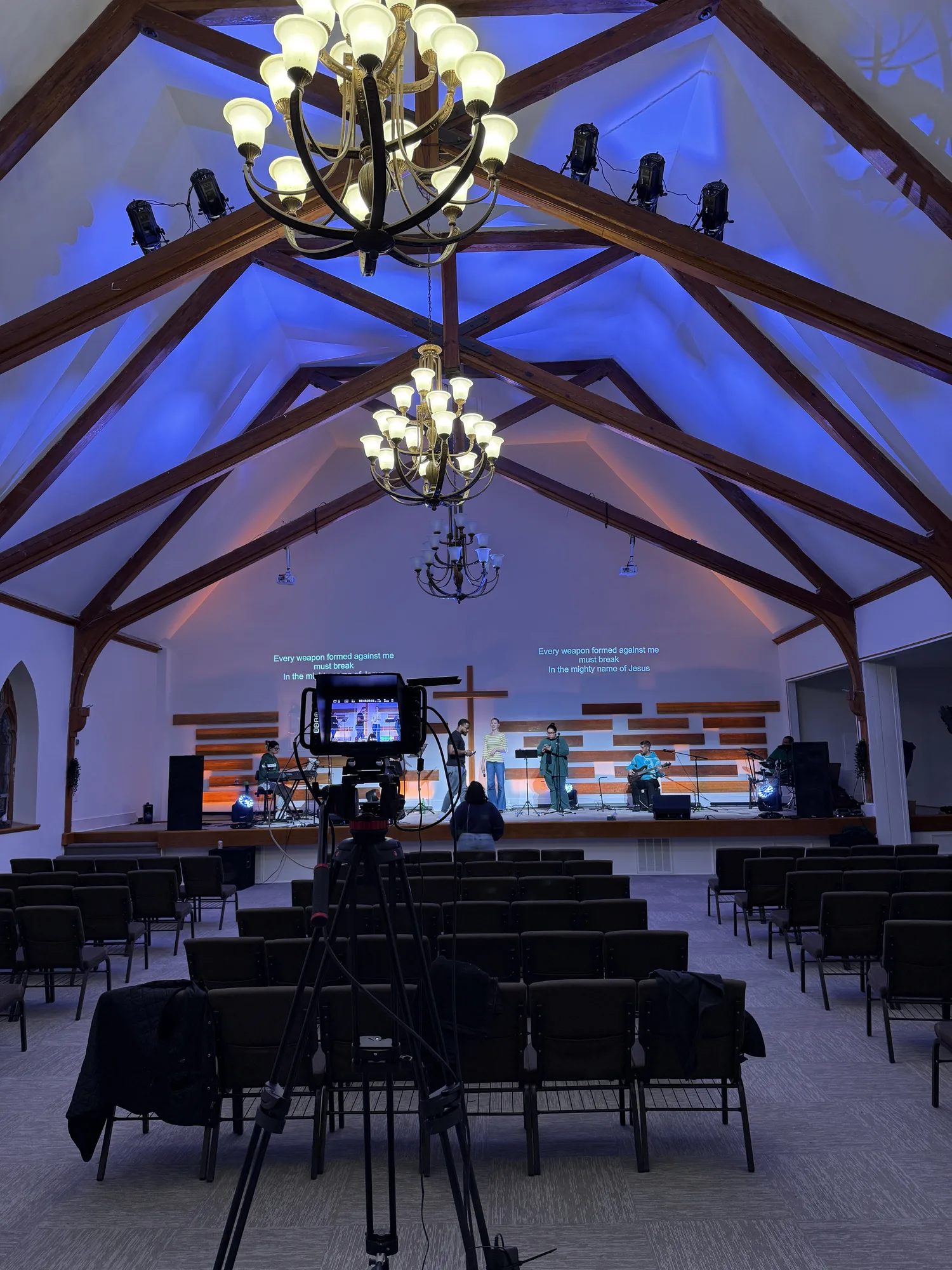 The Way Church sanctuary with blue room lighting, projected lyrics, and a camera facing the stage