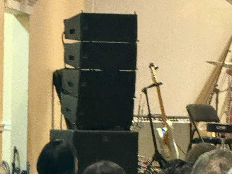 Church convention auditorium with loudspeaker coverage positioned beside seated attendees