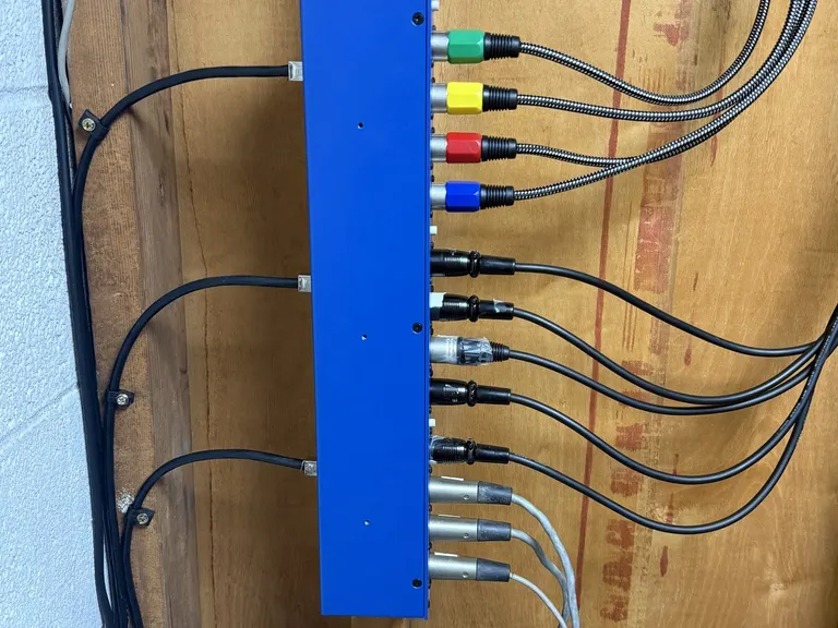Close-up of organized A/V cabling and connectors on a blue termination panel