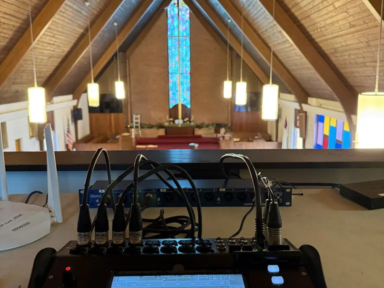 Digital audio console set up in the church sanctuary with the chancel visible in the background