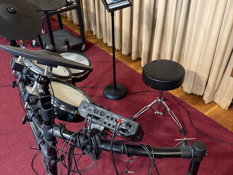 Electronic drum kit with connected audio hardware and monitor display in a church room