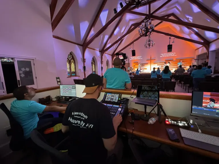 Live service production position with a digital mixer, presentation computer, and camera feeds overlooking The Way Church stage