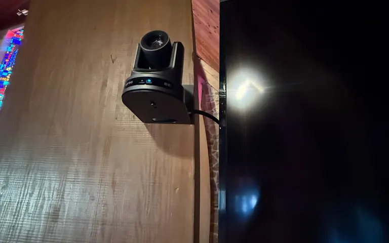 Mounted PTZ camera beside a wall display in the church sanctuary