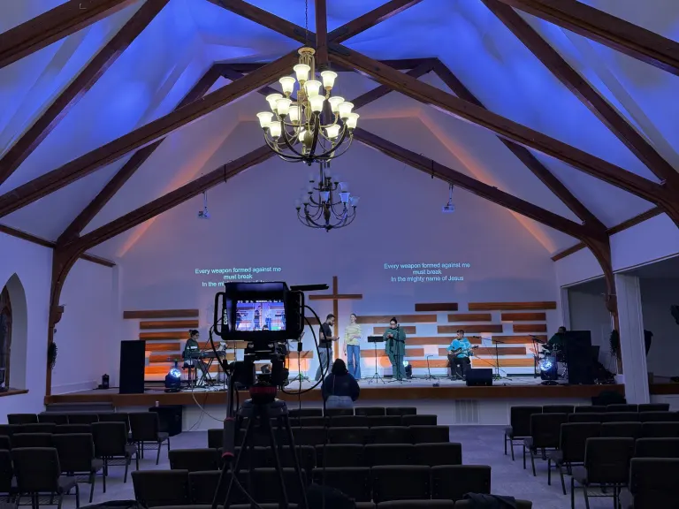 The Way Church sanctuary with blue room lighting, projected lyrics, and a camera facing the stage