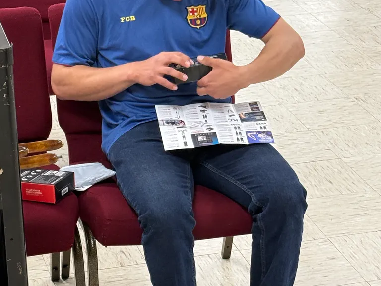 Church volunteer seated with an IEM pack and printed setup guide