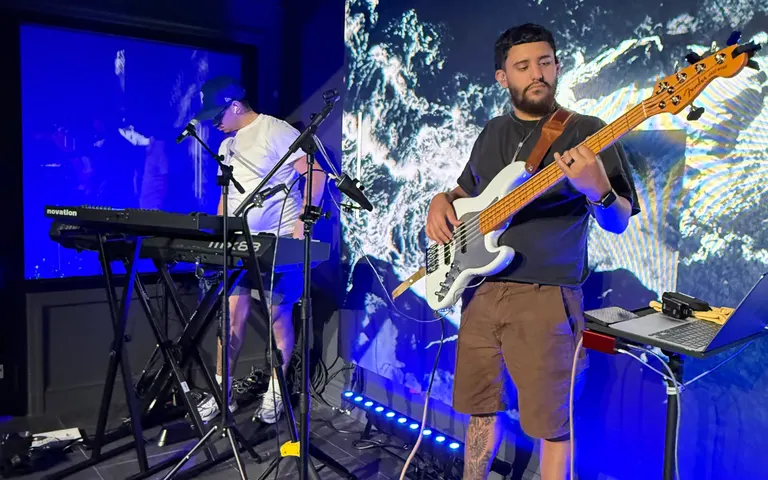 Bassist and keyboard player performing in front of a large LED wall during a church worship service