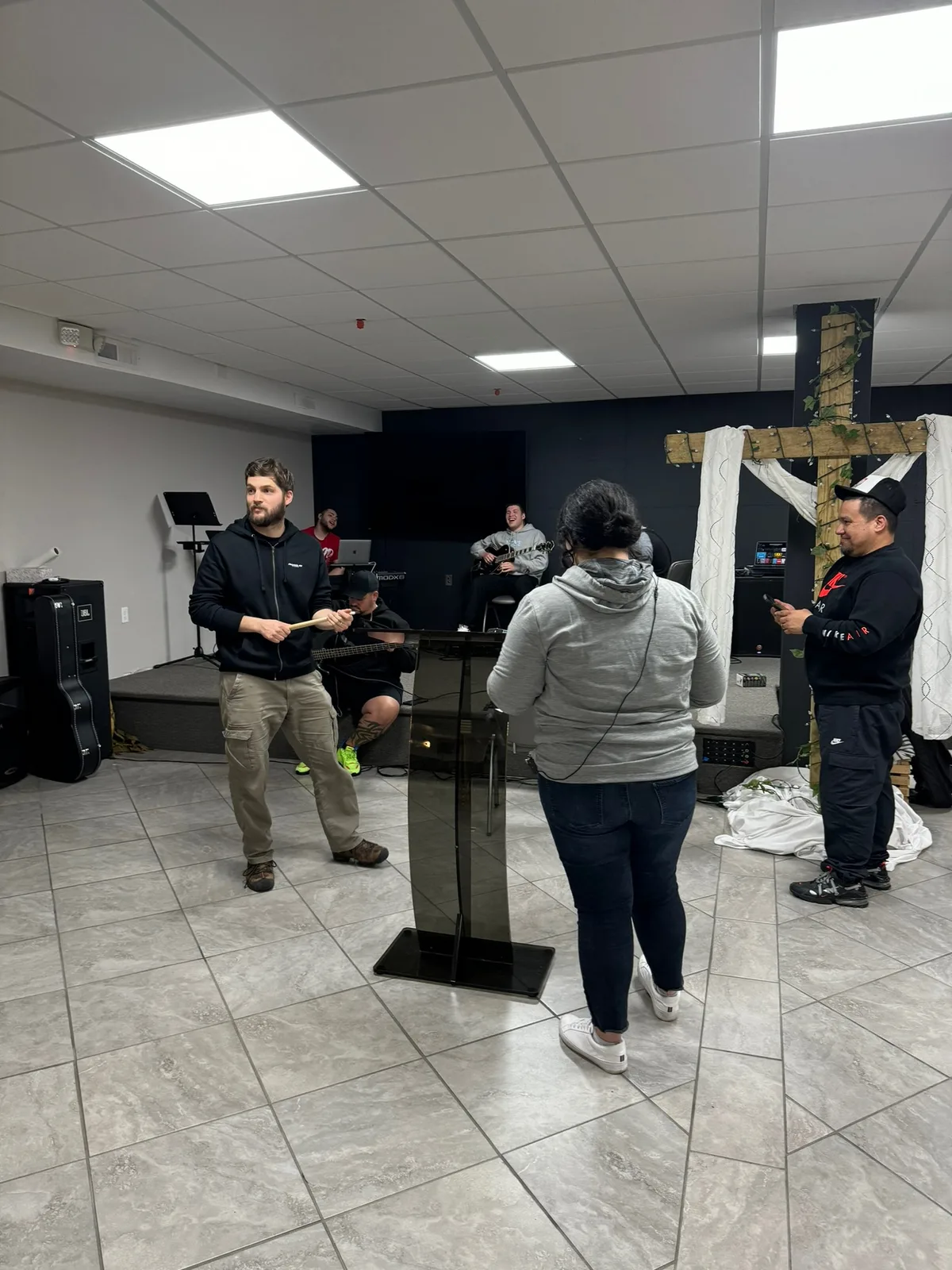 Church worship team leading live service with microphones, instruments, and stage lighting